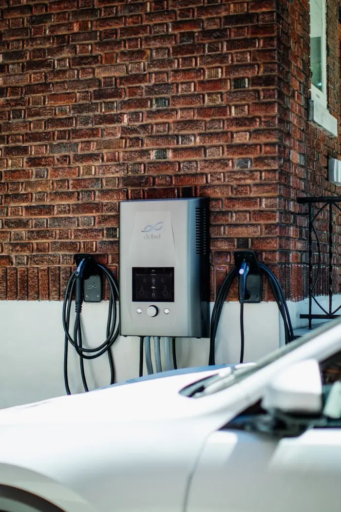 Wall-mounted electric vehicle charger on a brick wall